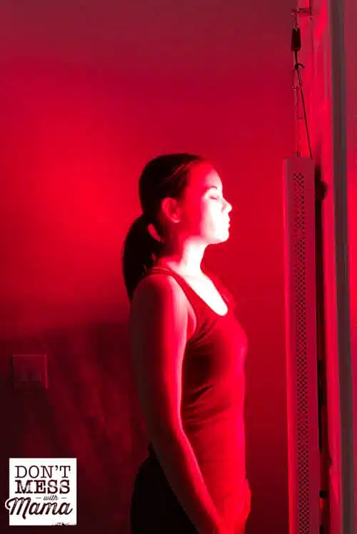 woman standing in front of a red light therapy unit