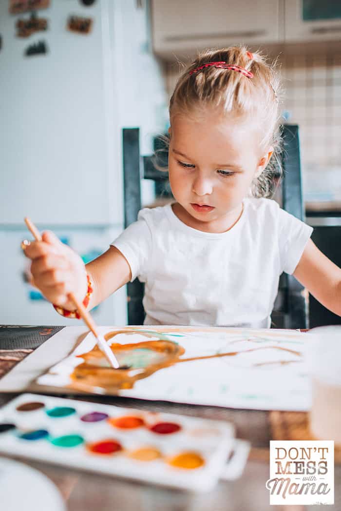 young girl painting with watercolors