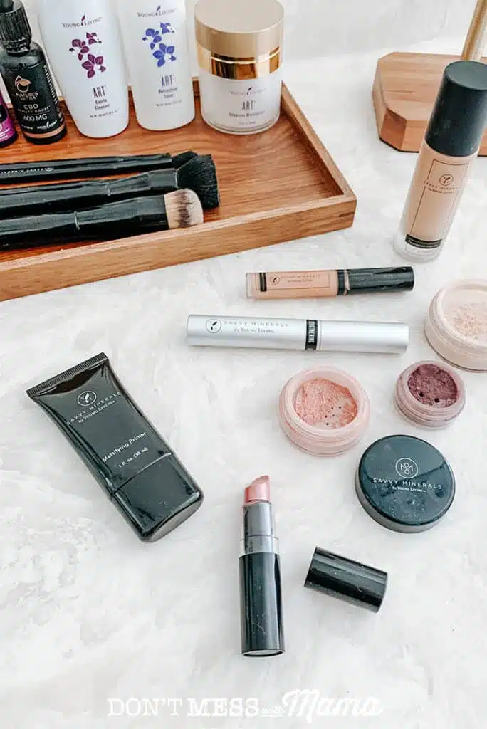 Savvy Minerals magnifying primer, lipstick, eye shadow, mascara, and foundation powder on a bathroom counter