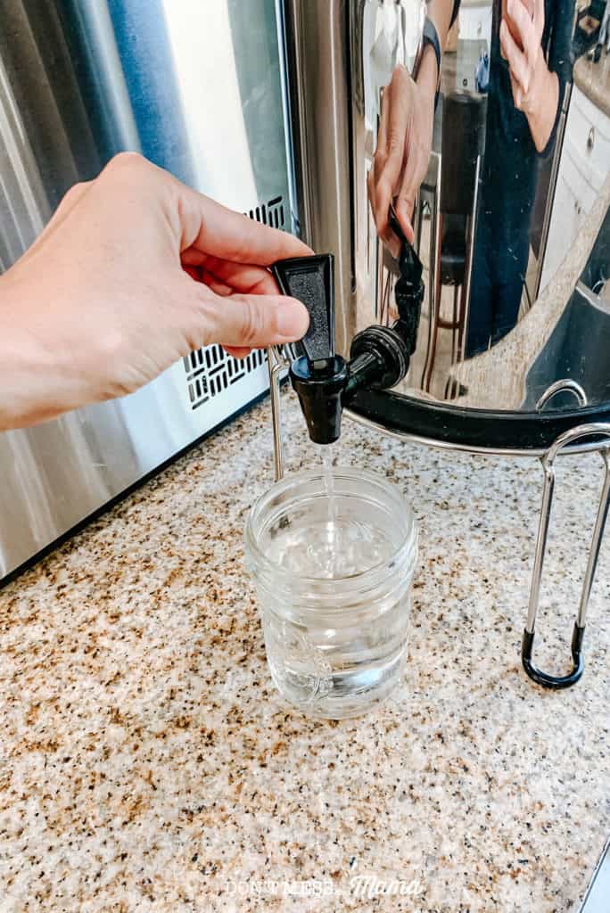 Pouring water from berkey water filter into mason jar