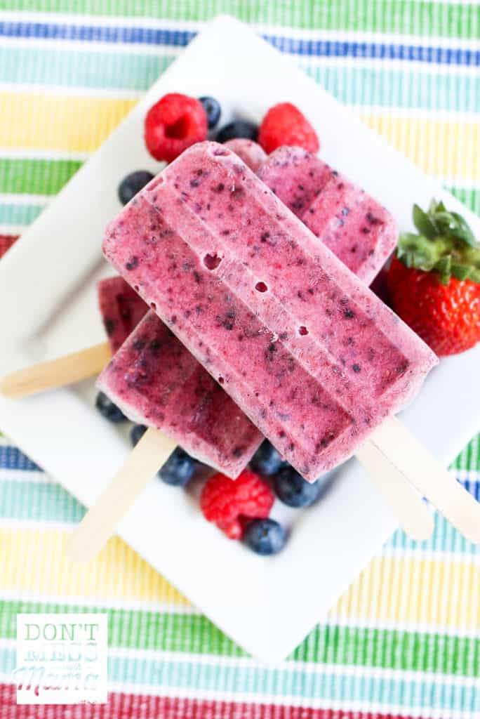 close up view of mixed berry popsicle with striped background