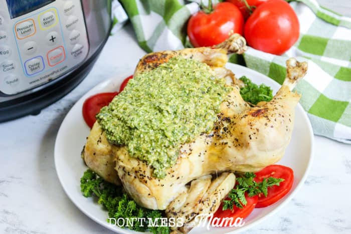 cooked whole chicken with pesto on a plate