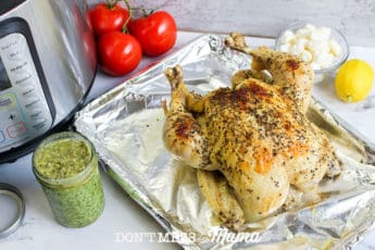 cooked whole chicken on tray with jar of pesto