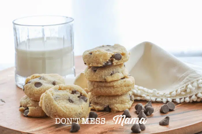 stack of chocolate chip cookies next to glass of milk