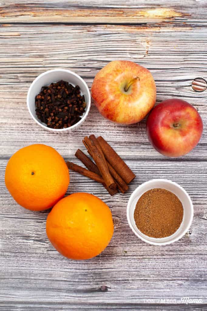 orange, apples, cinnamon, clove on a table - ingredients for fall potpourri
