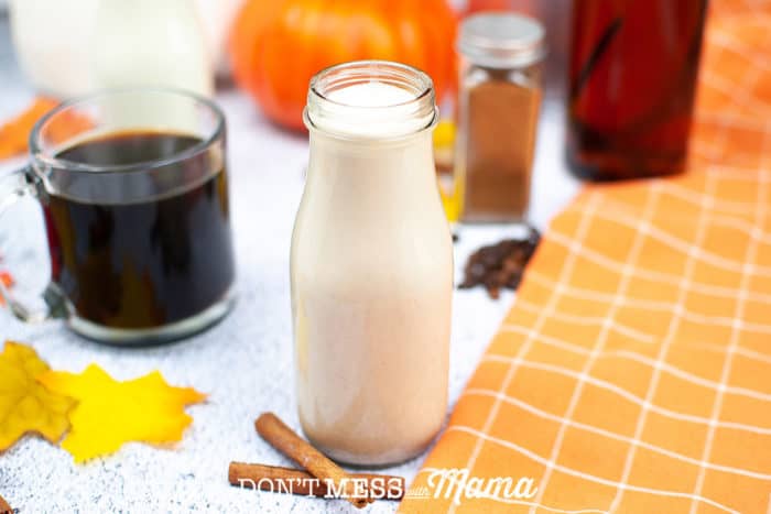 bottle of coffee creamer with coffee and pumpkin in background