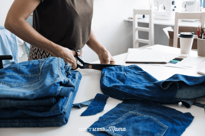woman cutting demin jeans with scissors on a table
