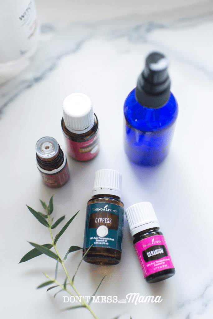 geranium and cypress essential oil with blue spray bottle