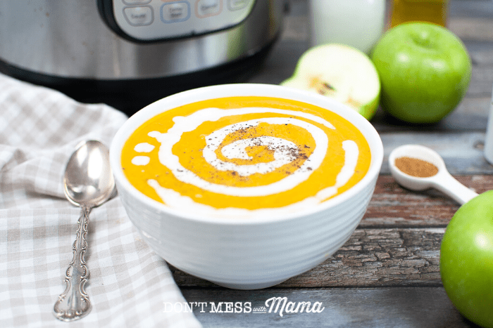 white bowl with butternut squash soup and swirl of coconut cream