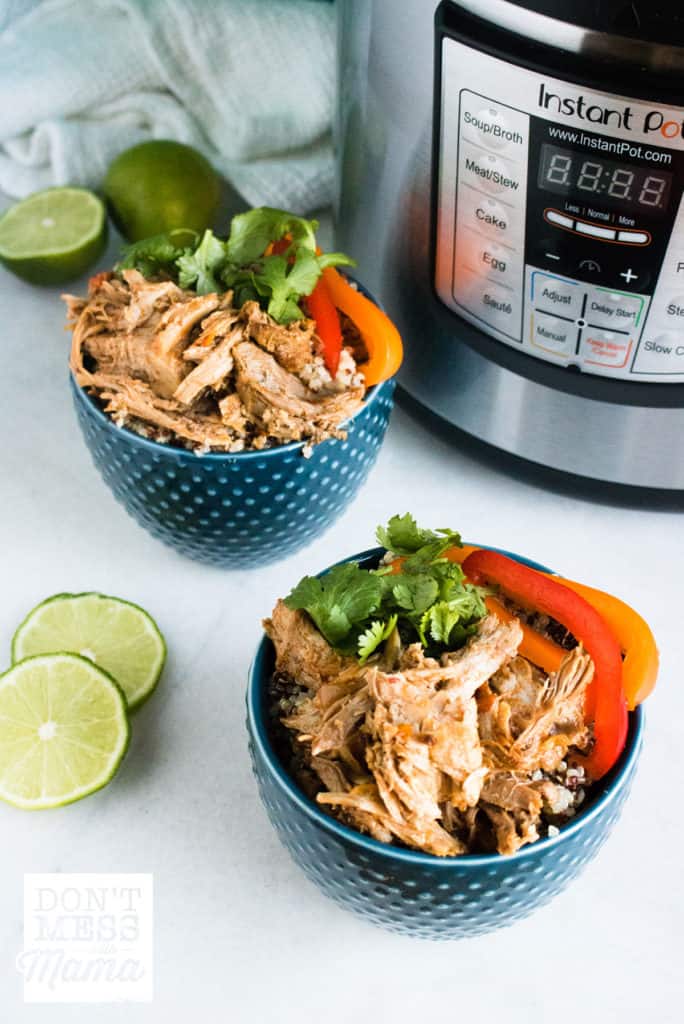 two blue bowls of pork carnitas with instant pot in background