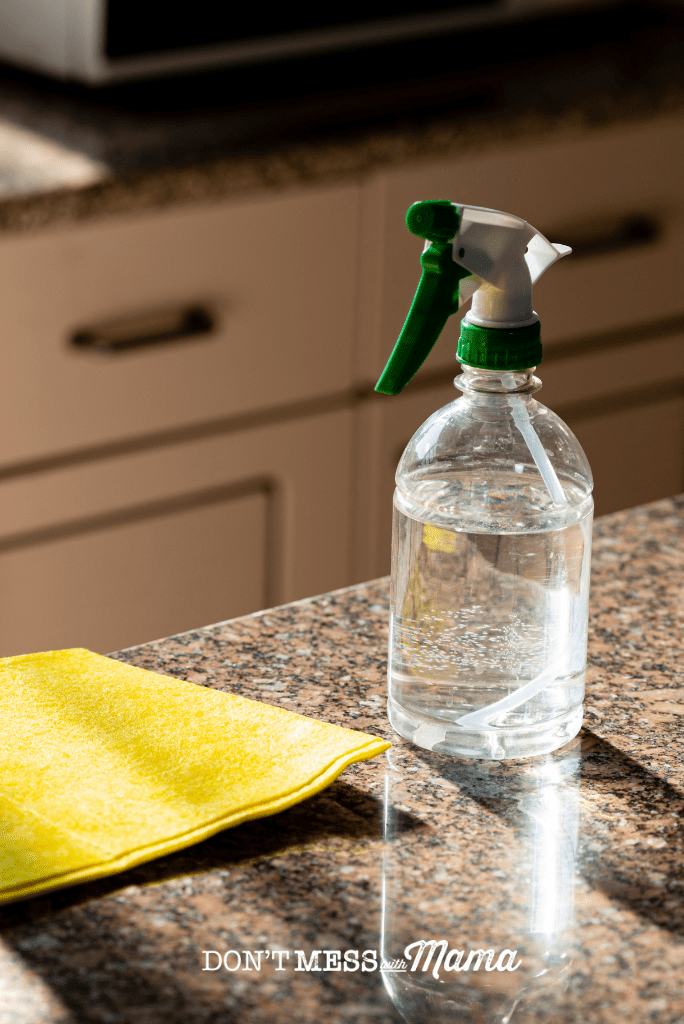 spray bottle with citric acid spray and yellow cloth on kitchen surface