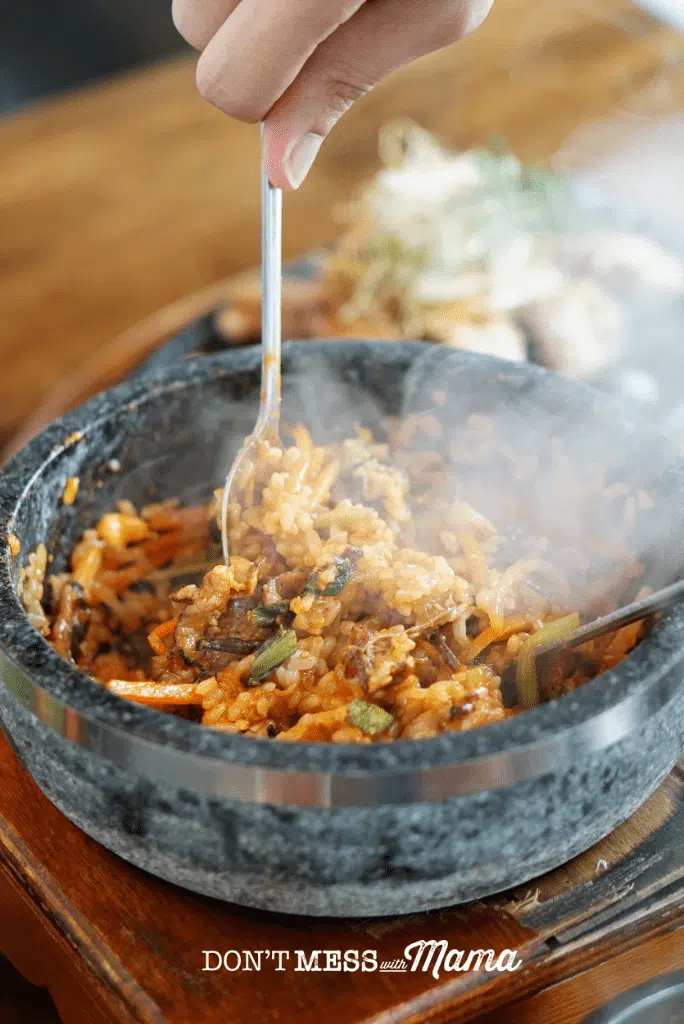 korean clay bowl with steaming rice and vegetables