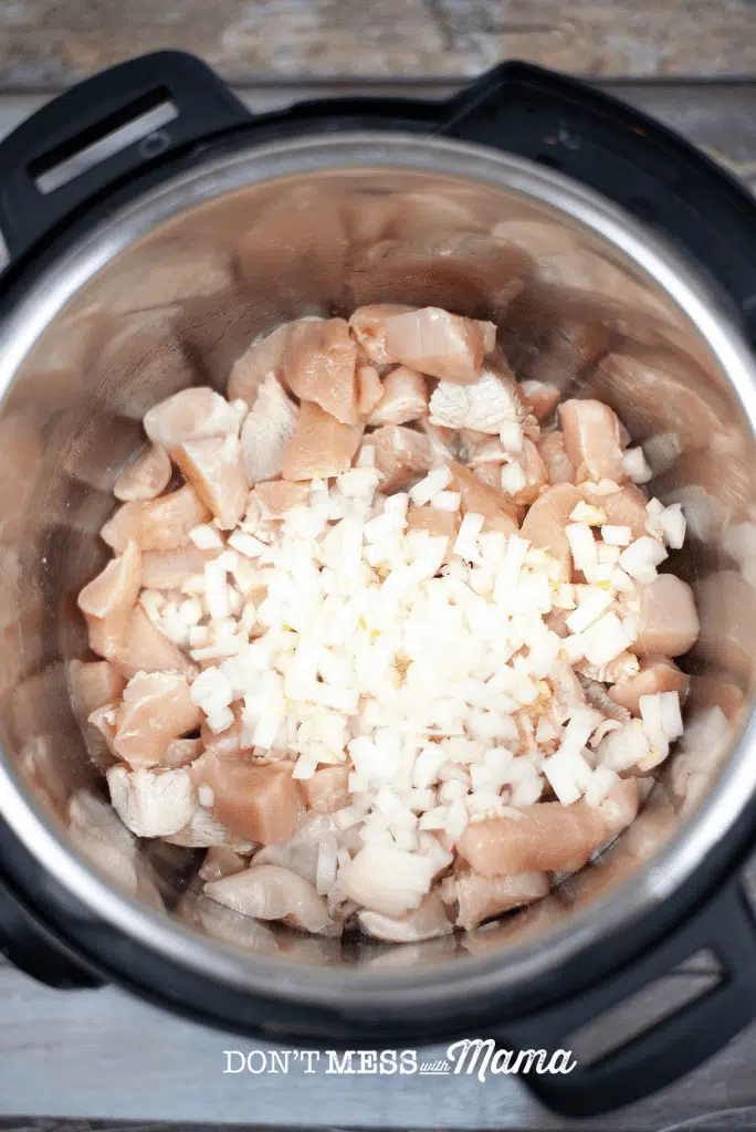 chopped raw chicken breasts and chopped onion in an instant pot