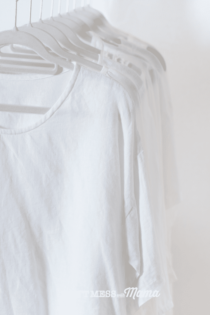 collection of white t shirts on hangers