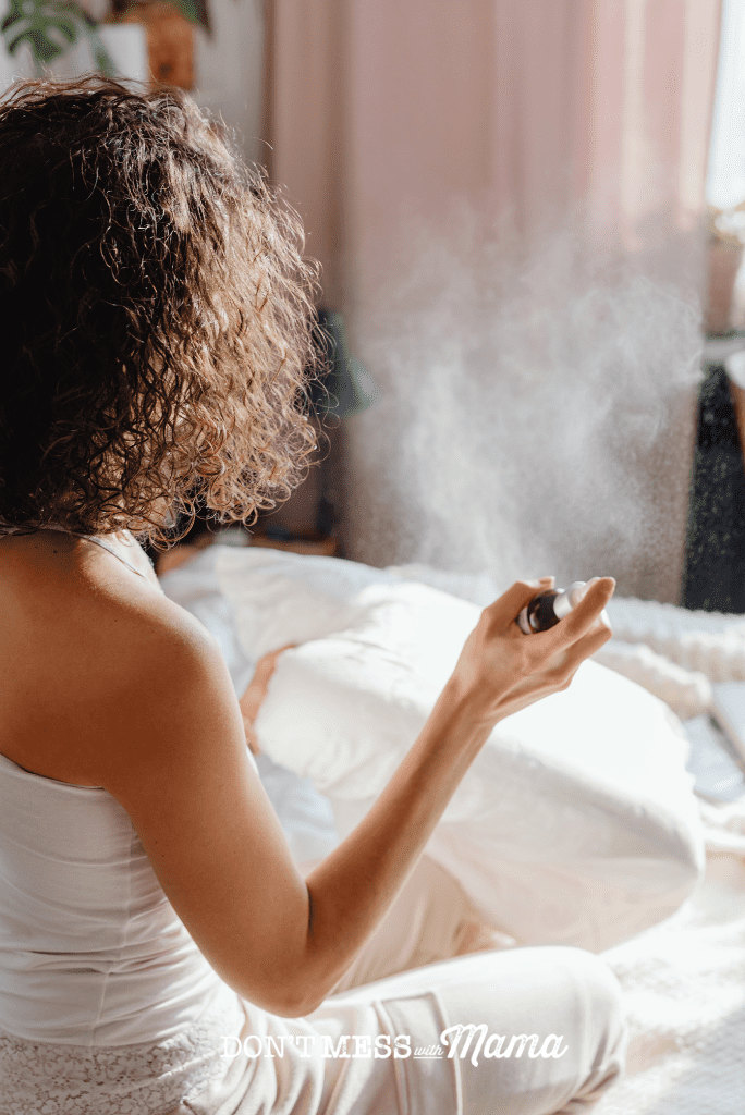 woman with curly hair spraying bedding