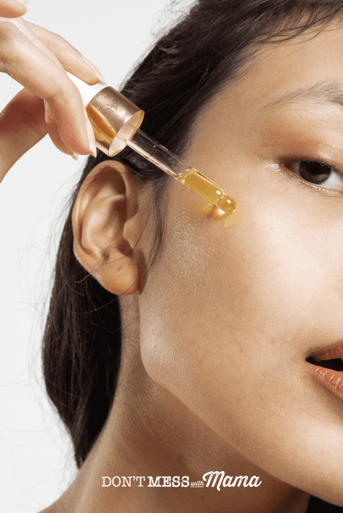 woman using jojoba oil on face