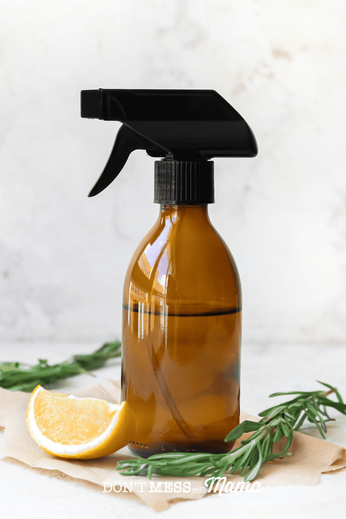 amber glass bottle with lemon wedge and rosemary