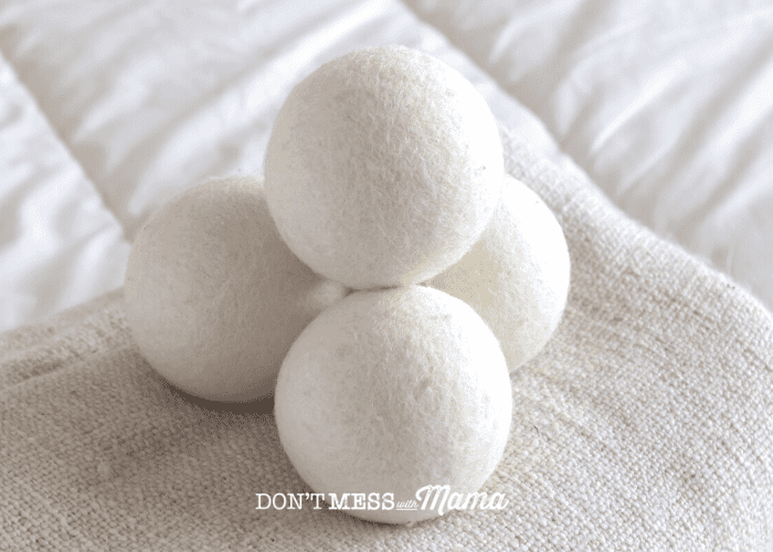 pile of 4 wool dryer balls on white blanket