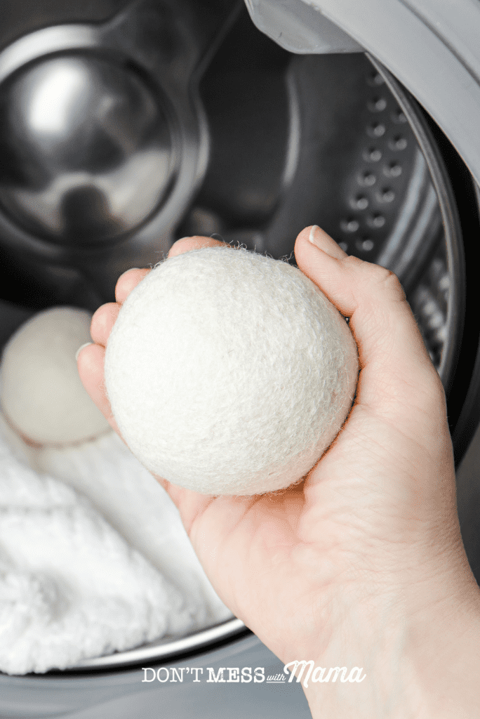 hand holding wool dryer ball in front of dryer