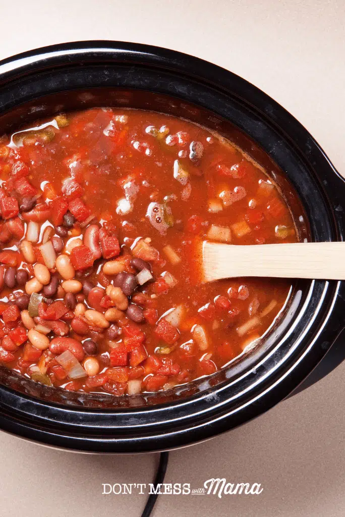 slow cooker with bean chili and spoon
