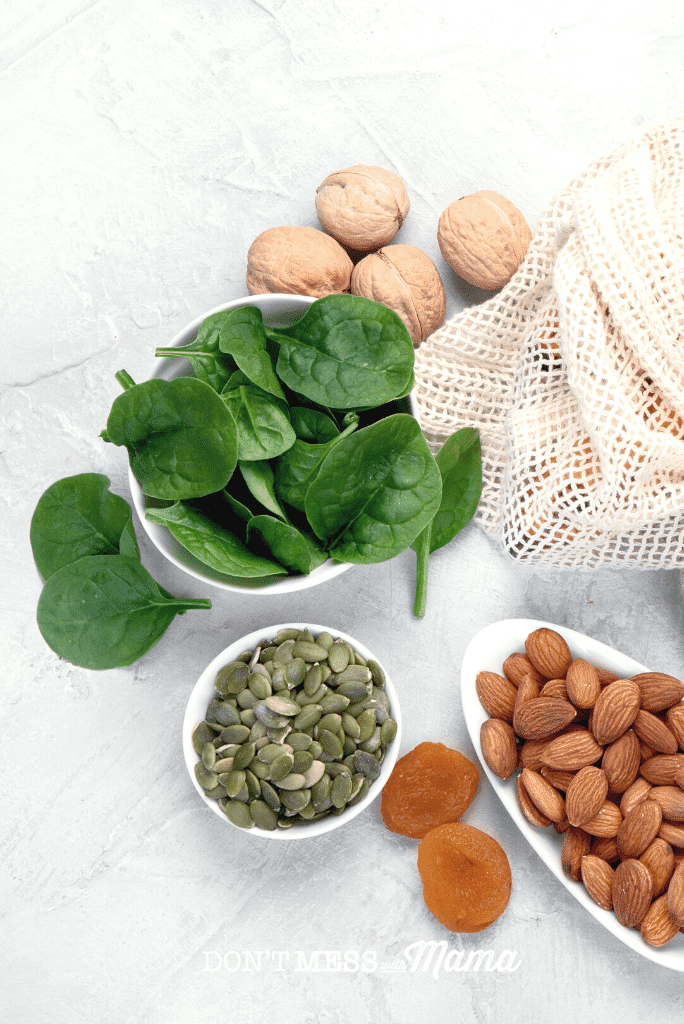 almonds spinach walnuts in white dishes