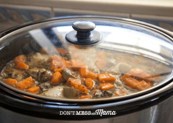 slow cooker with carrot and meat stew inside