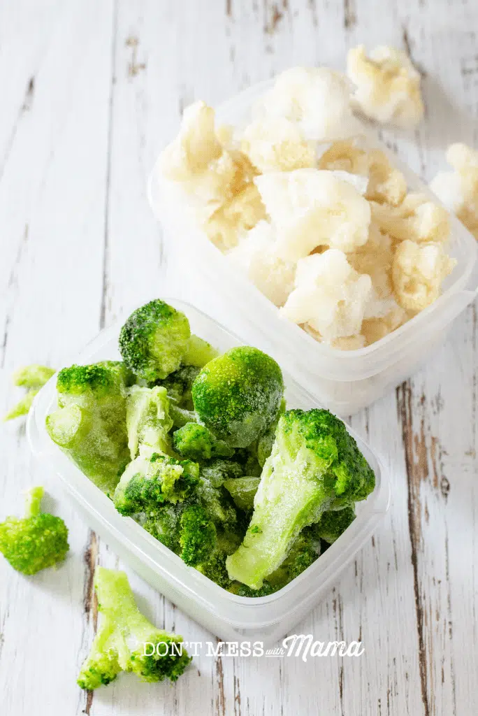 plastic containers with frozen broccoli and cauliflower