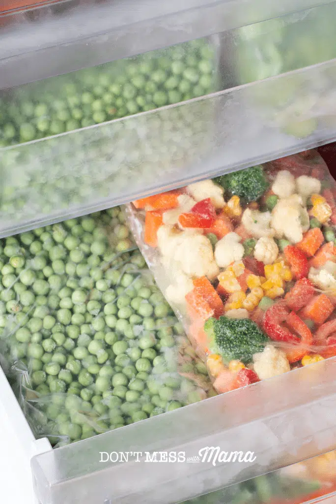 freezer drawer with freezer bags of peas and vegetables