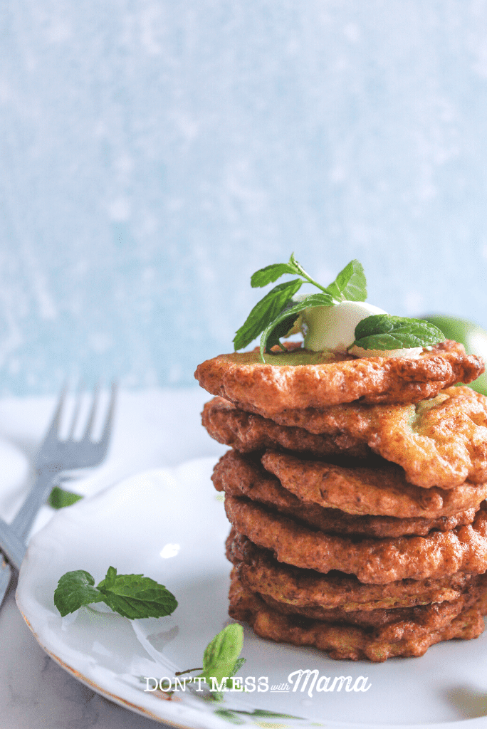stack of zucchini fritters on white plate with fork