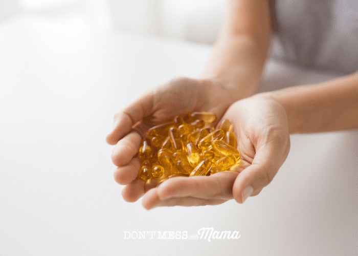 cupped hands holding cod liver oil supplements
