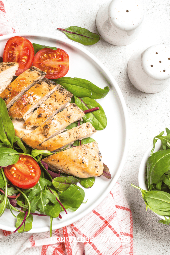 chicken breast on plate with salad