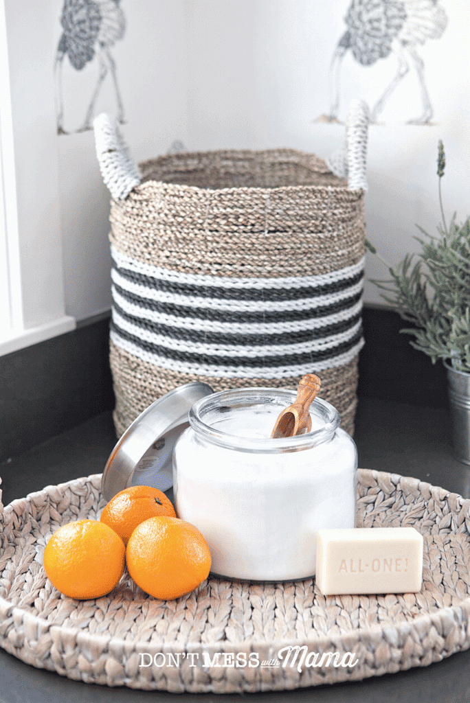 natural laundry detergent in glass jar with oranges and jute basket