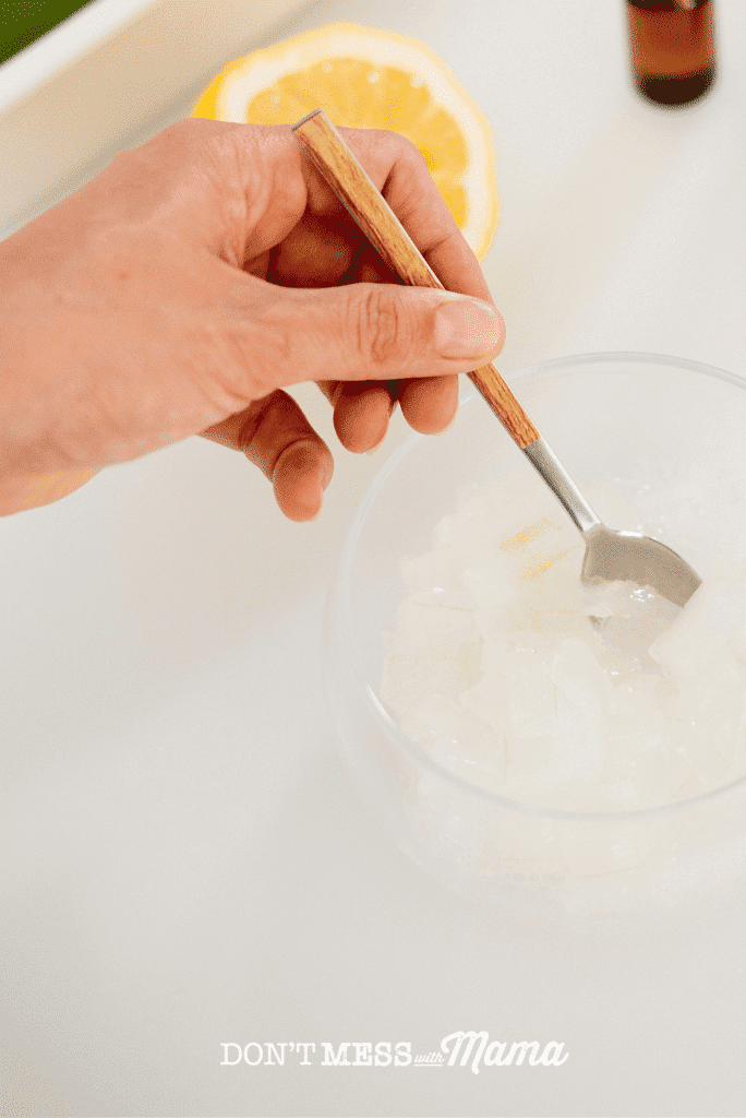 stirring aloe vera gel and lemon in a glass bowl with spoon