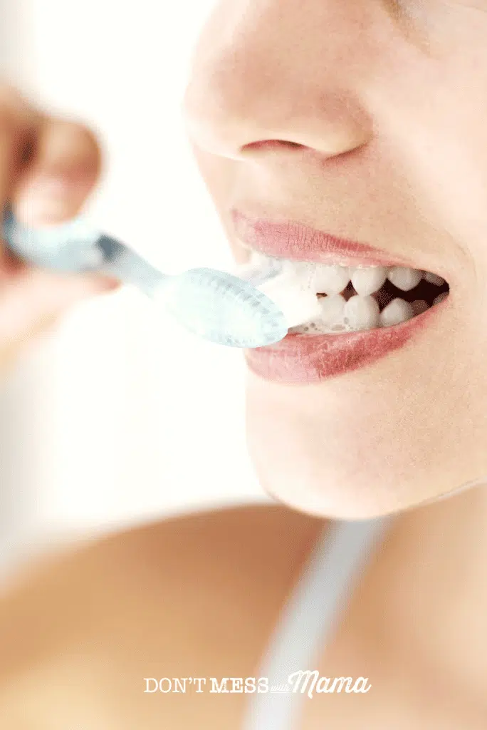 woman brushing teeth with blue tooth brush