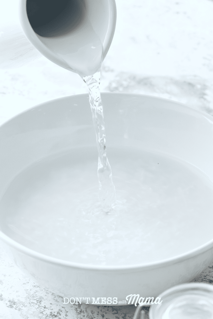 white jug adding water to bowl of rice