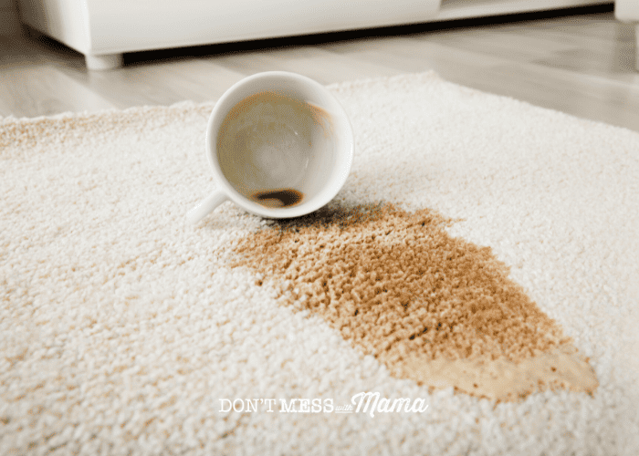 white mug spilling black coffee on rug