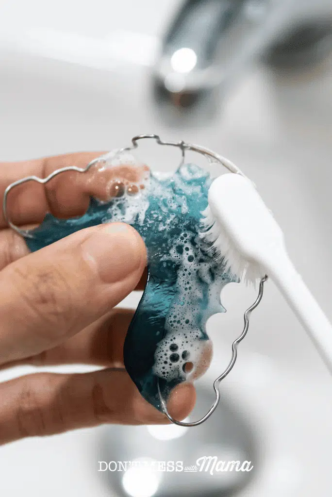 toothbrush scrubbing baking soda paste on retainers