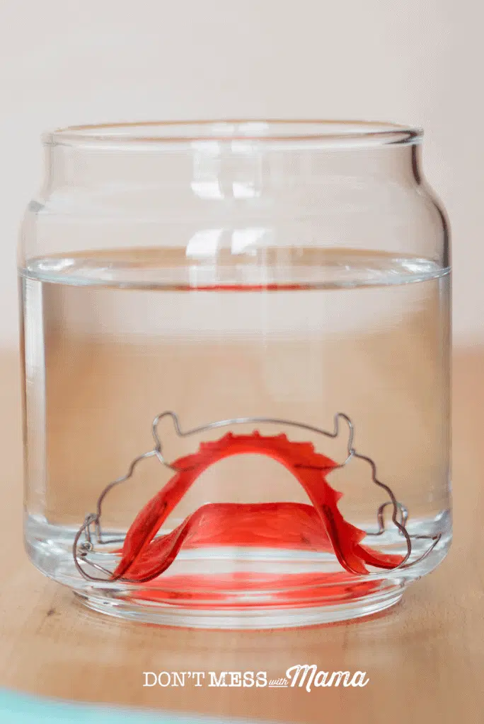red metal retainer in glass of water