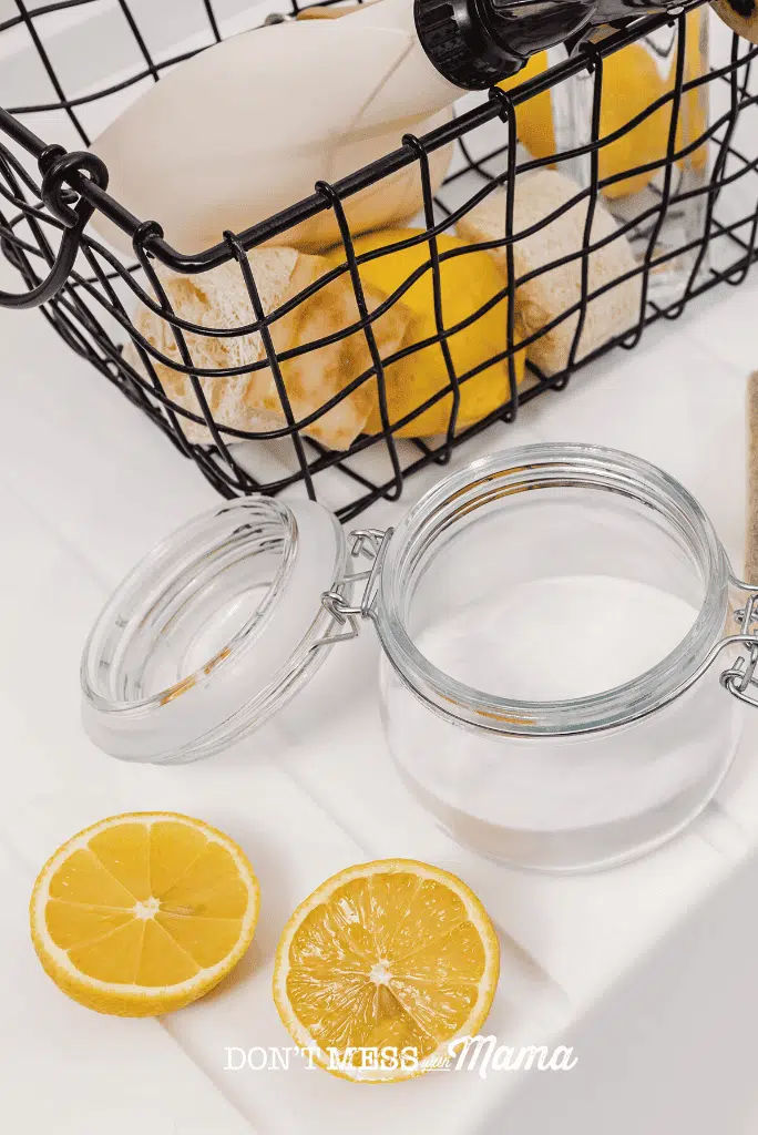 jar of baking soda with lemon slices and basket to get rid of drain smells