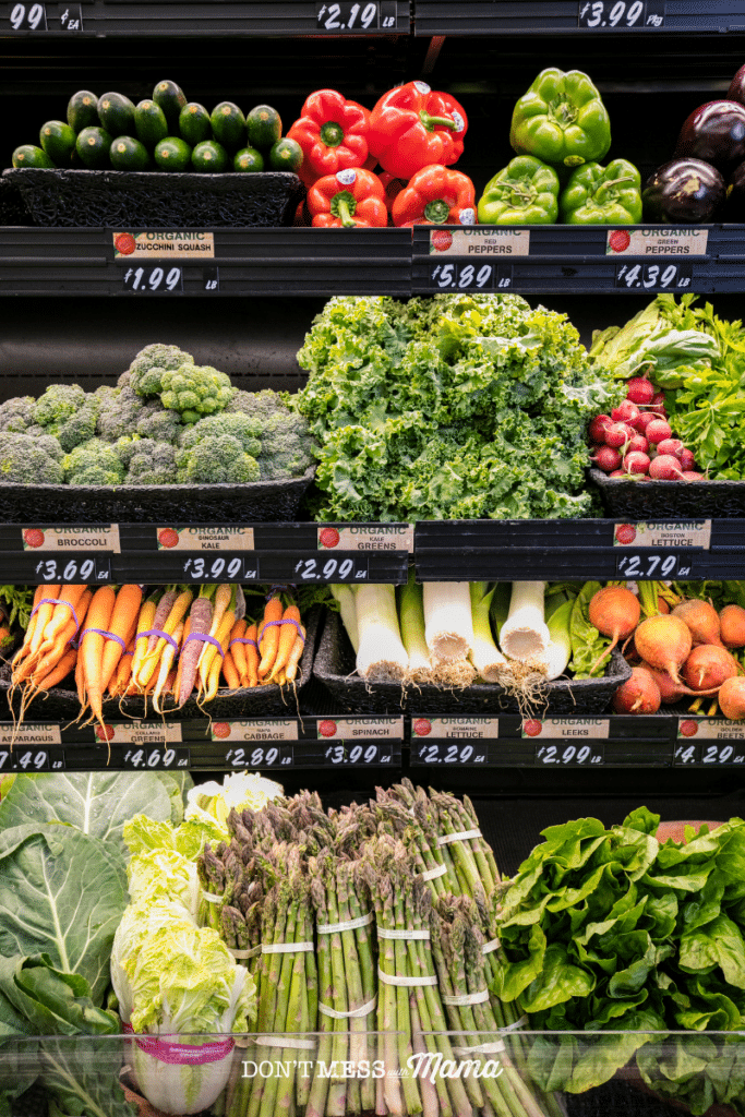 organic vegetables in a grocery store like carrots, broccoli, asparagus with price tags