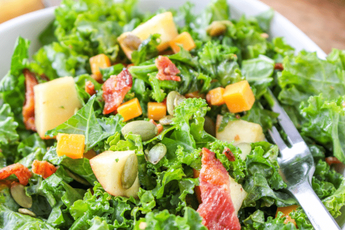 closeup of kale salad with cheddar and apples